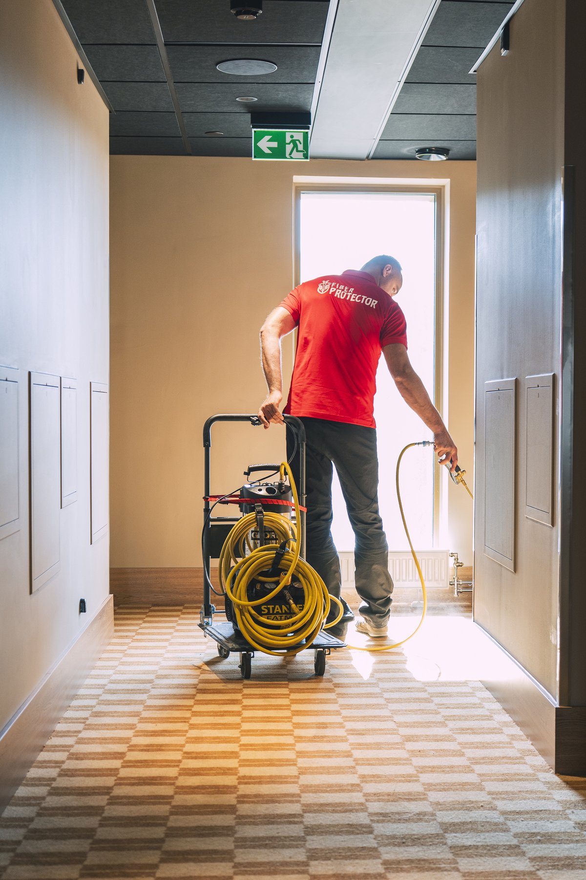 Fiber ProTector-tekniker impregnerar matta i hotellkorridor