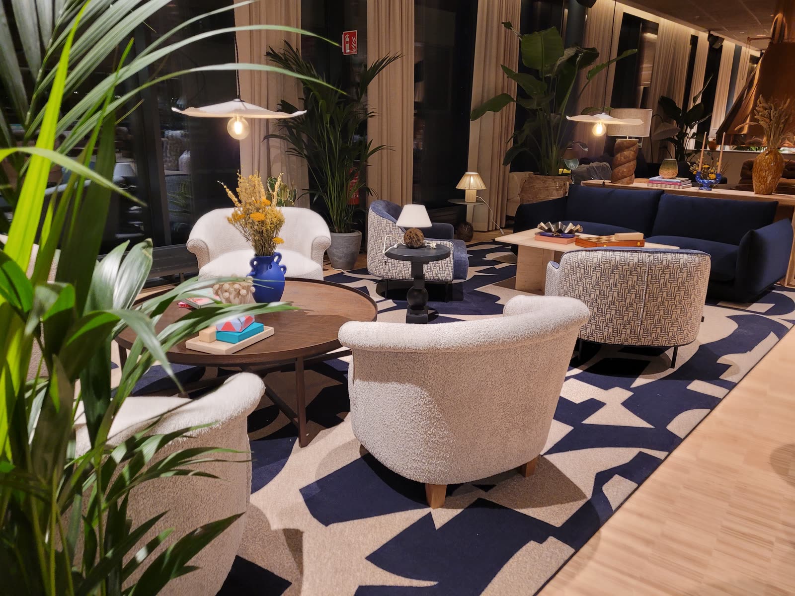 Lobbylounge med bouclefåtöljer och mönstrad matta