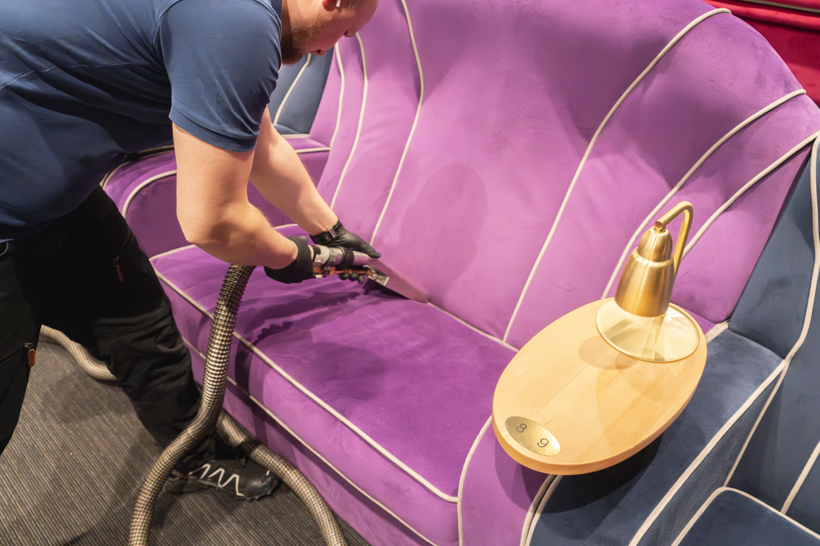 Fiber ProTector-tekniker djuprengör violett velursoffa på biograf