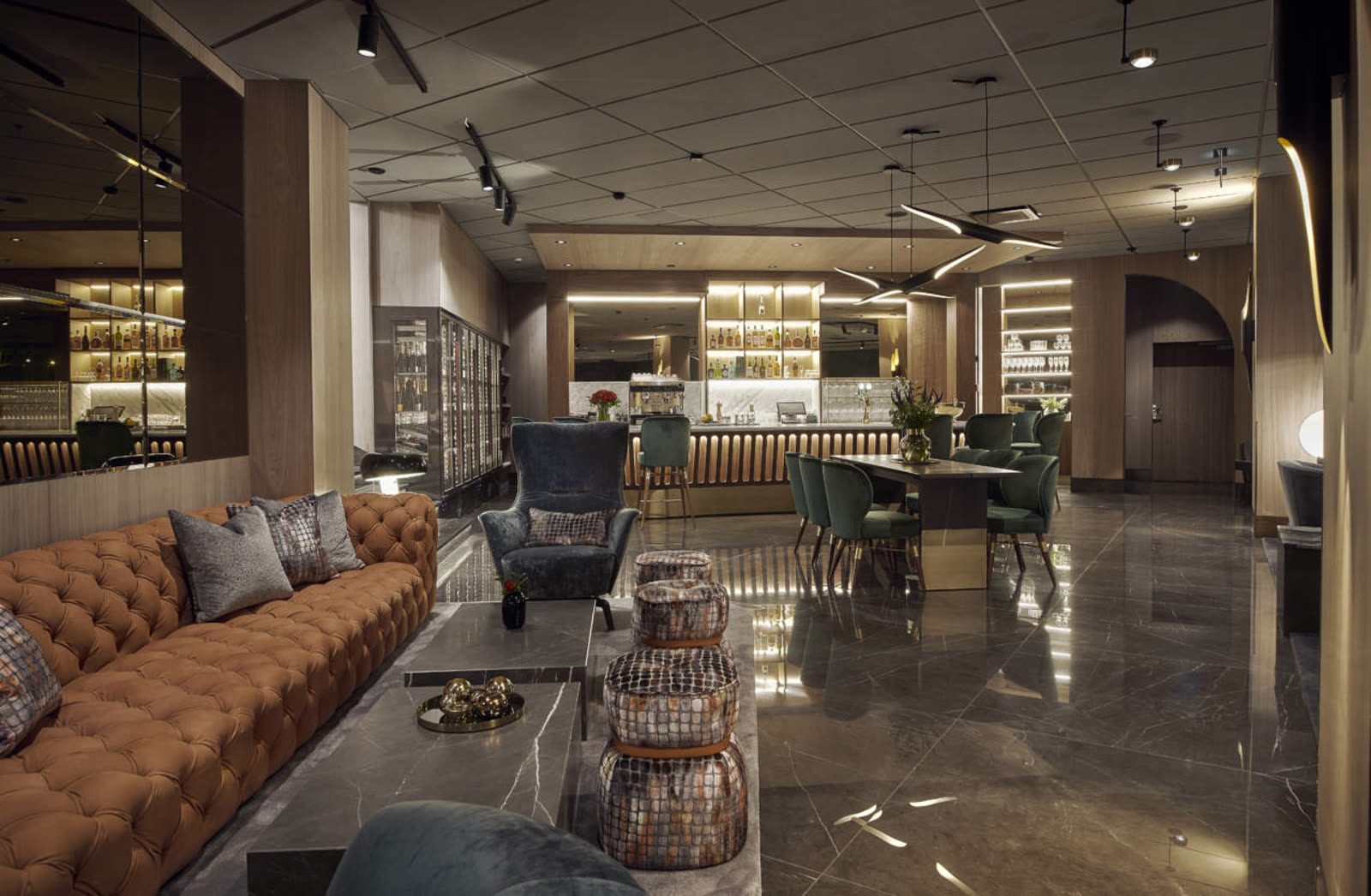 Barlounge i marmor med svängd velursoffa och ottomaner i krokodilmönstrat skinn