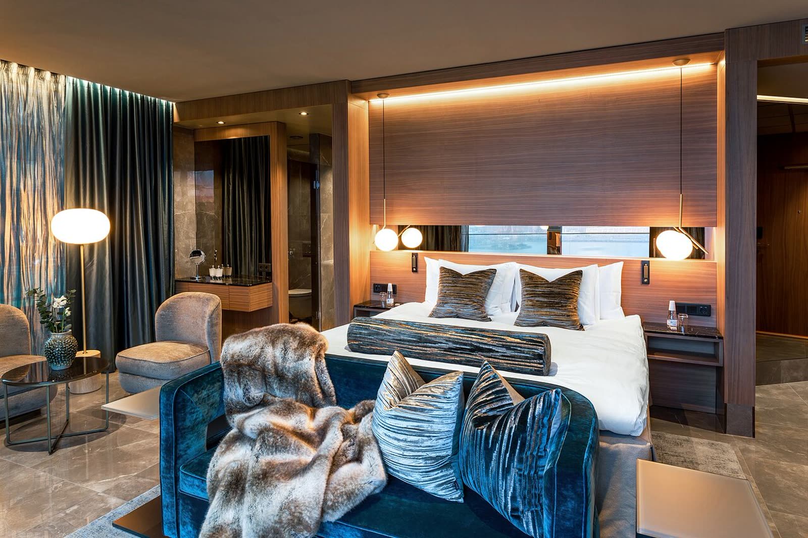Barlounge med brun chesterfieldsoffa i skinn och velurottomaner