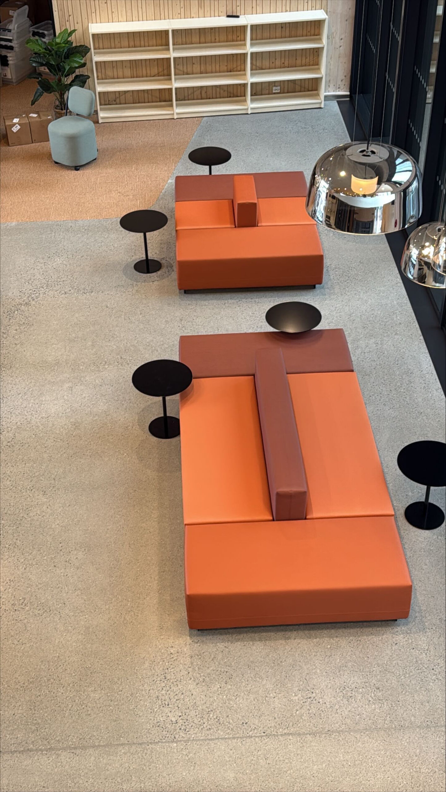Skolans loungeområde med orange soffmoduler och matta